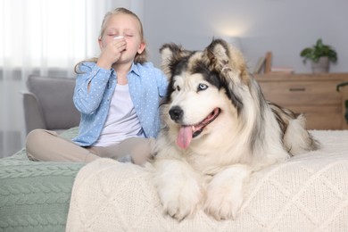 Photo of Girl suffering from allergy with her dog on bed at home