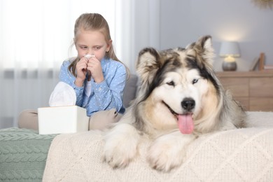 Photo of Girl suffering from allergy with her dog on bed at home