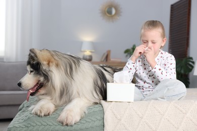 Photo of Girl suffering from allergy with her dog on bed at home