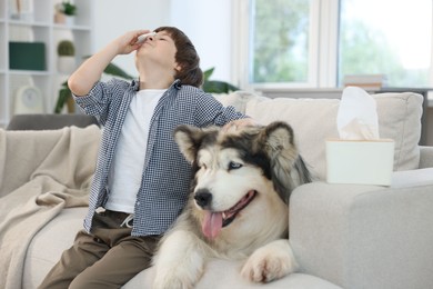 Photo of Boy suffering from allergy with her dog on sofa at home