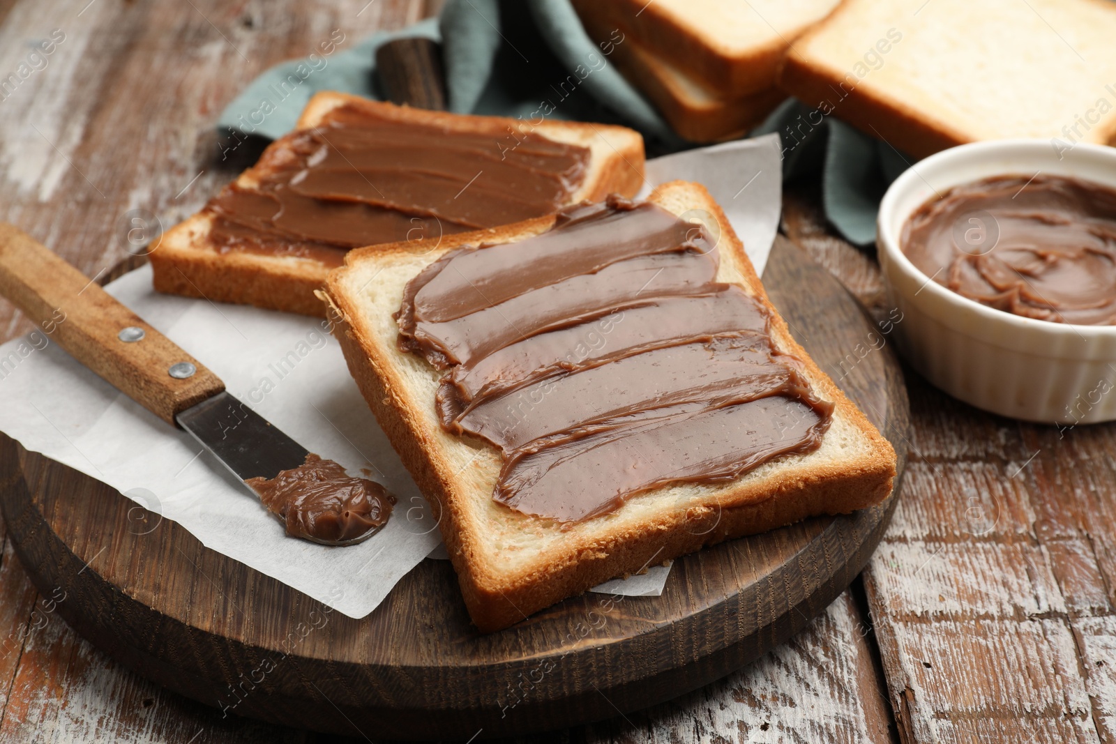 Sandwiches with chocolate butter and knife on wooden table, closeup Photo of Sandwiches with chocolate butter and knife on wooden table, closeup