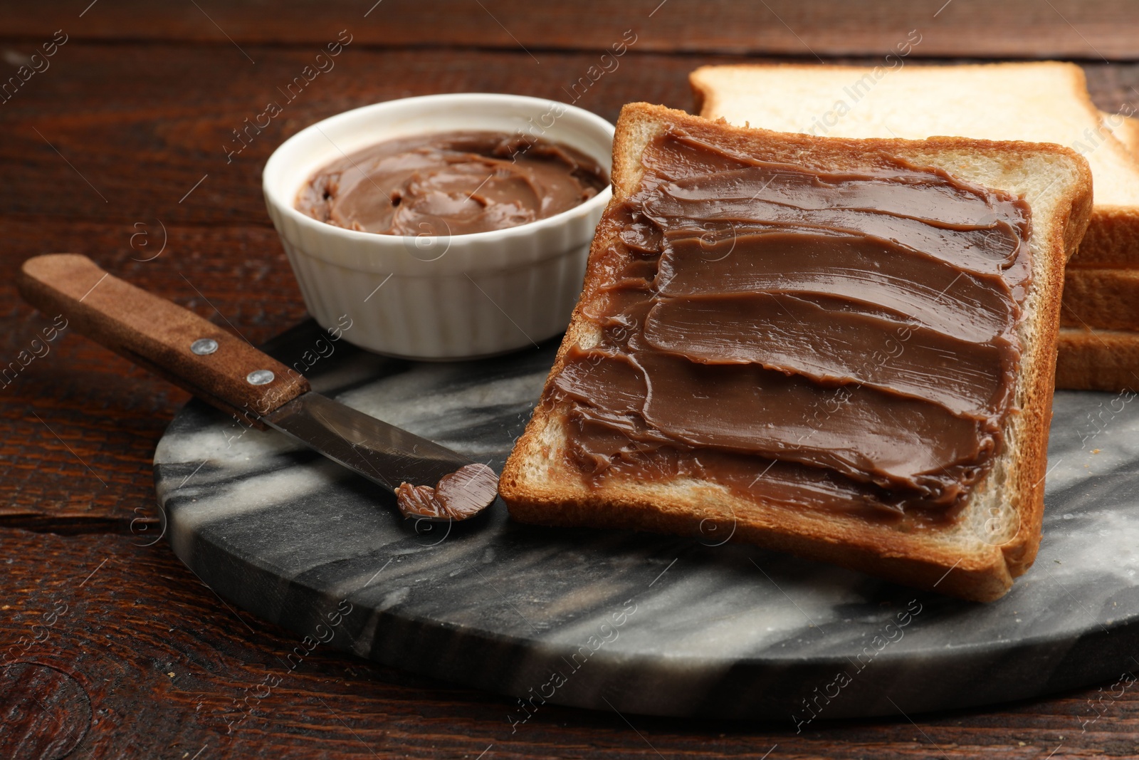 Sandwiches with chocolate butter and knife on wooden table, closeup Photo of Sandwiches with chocolate butter and knife on wooden table, closeup