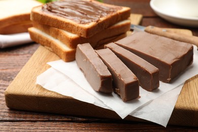 Photo of Sandwiches with chocolate butter on wooden table, closeup