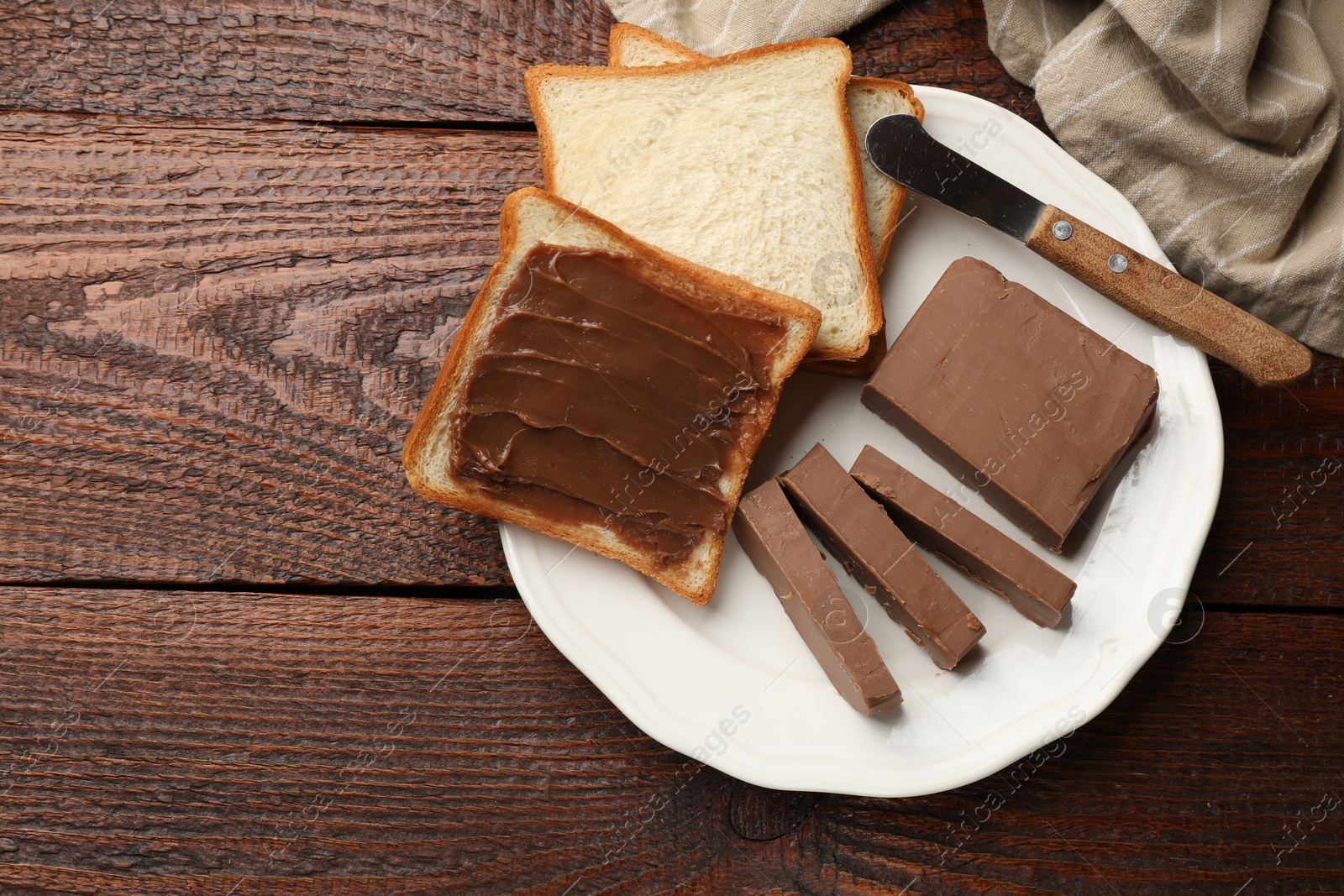 Sandwiches with chocolate butter and knife on wooden table, top view. Space for text Photo of Sandwiches with chocolate butter and knife on wooden table, top view. Space for text