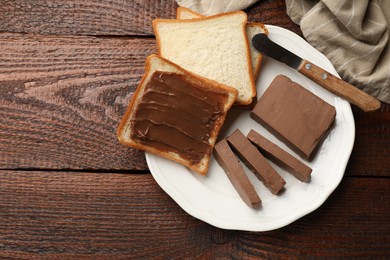 Photo of Sandwiches with chocolate butter and knife on wooden table, top view. Space for text