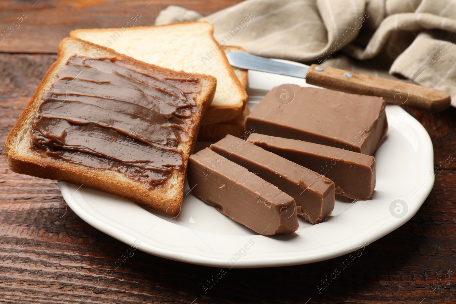 Sandwiches with chocolate butter and knife on wooden table, closeup Photo of Sandwiches with chocolate butter and knife on wooden table, closeup