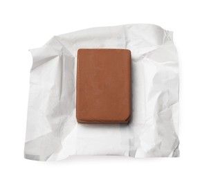 Photo of Block of tasty chocolate butter in open package isolated on white, top view