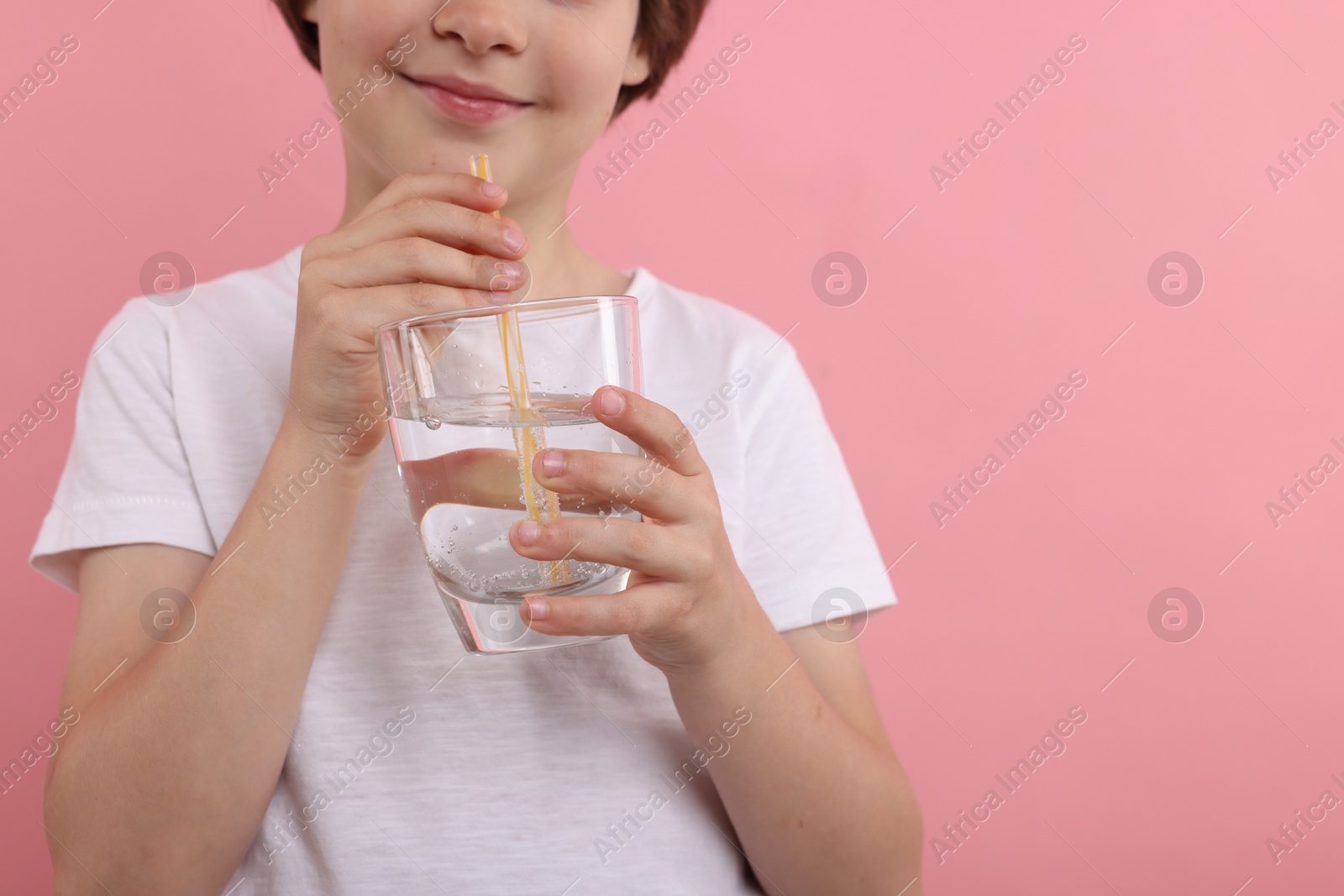 Little boy with glass of refreshing soda drink on pink background, closeup. Space for text Photo of Little boy with glass of refreshing soda drink on pink background, closeup. Space for text