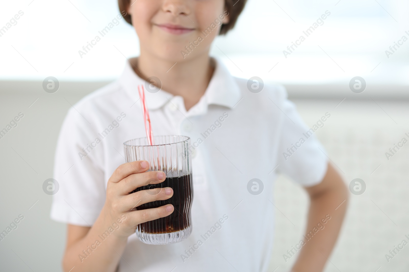 Little boy with glass of refreshing soda at home, selective focus Photo of Little boy with glass of refreshing soda at home, selective focus