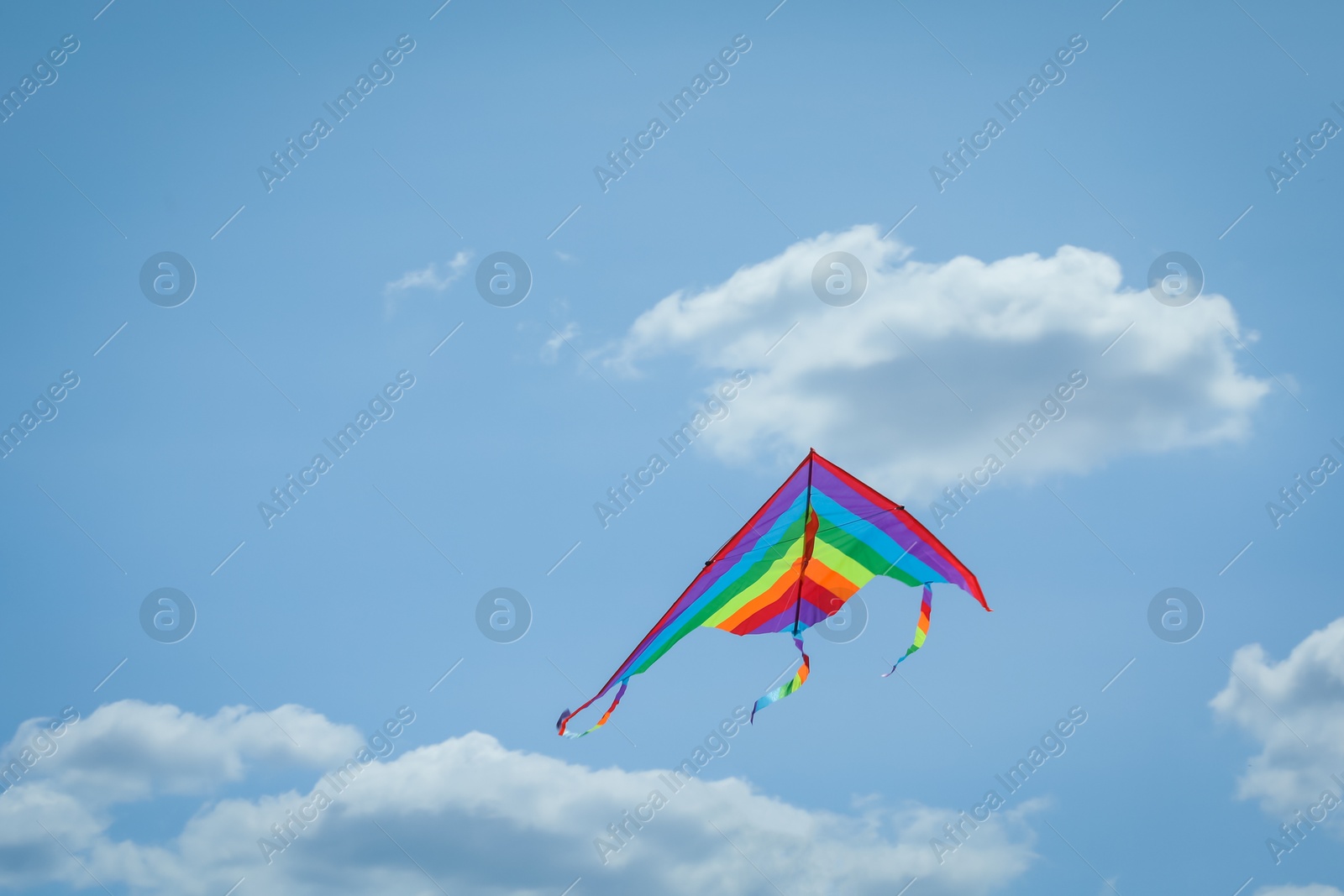 Colorful kite flying in blue sky, low angle view. Space for text Photo of Colorful kite flying in blue sky, low angle view. Space for text
