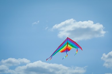 Photo of Colorful kite flying in blue sky, low angle view. Space for text