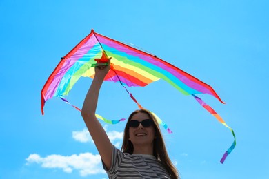 Photo of Woman with colorful kite under blue sky, low angle view
