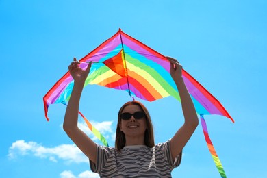 Photo of Woman with colorful kite under blue sky, low angle view