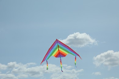 Photo of Colorful kite flying in blue sky, low angle view