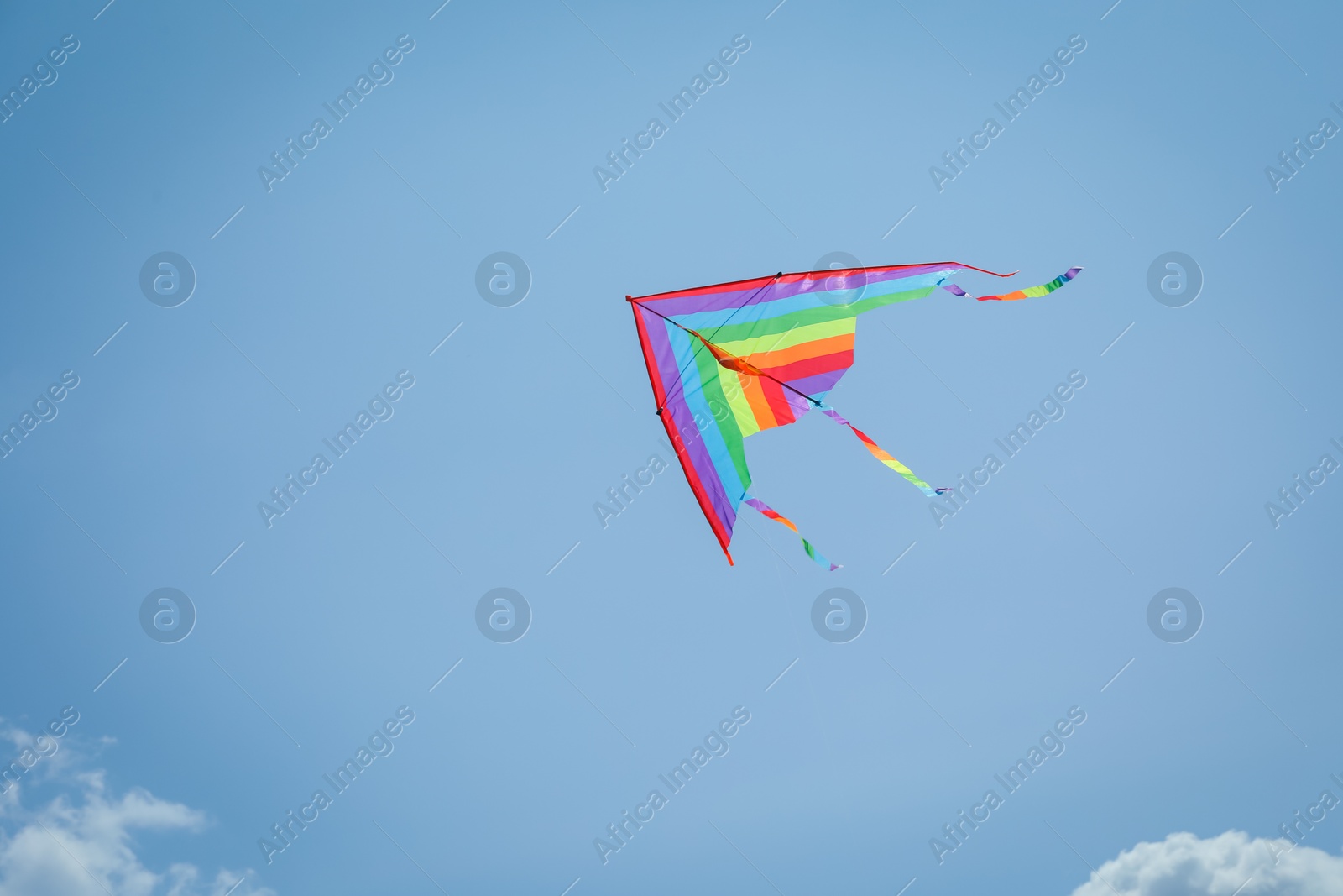 Colorful kite flying in blue sky, low angle view. Space for text Photo of Colorful kite flying in blue sky, low angle view. Space for text