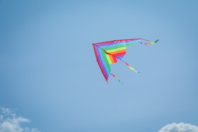 Photo of Colorful kite flying in blue sky, low angle view. Space for text