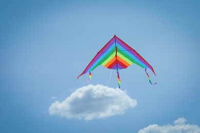 Photo of Colorful kite flying in blue sky, low angle view. Space for text