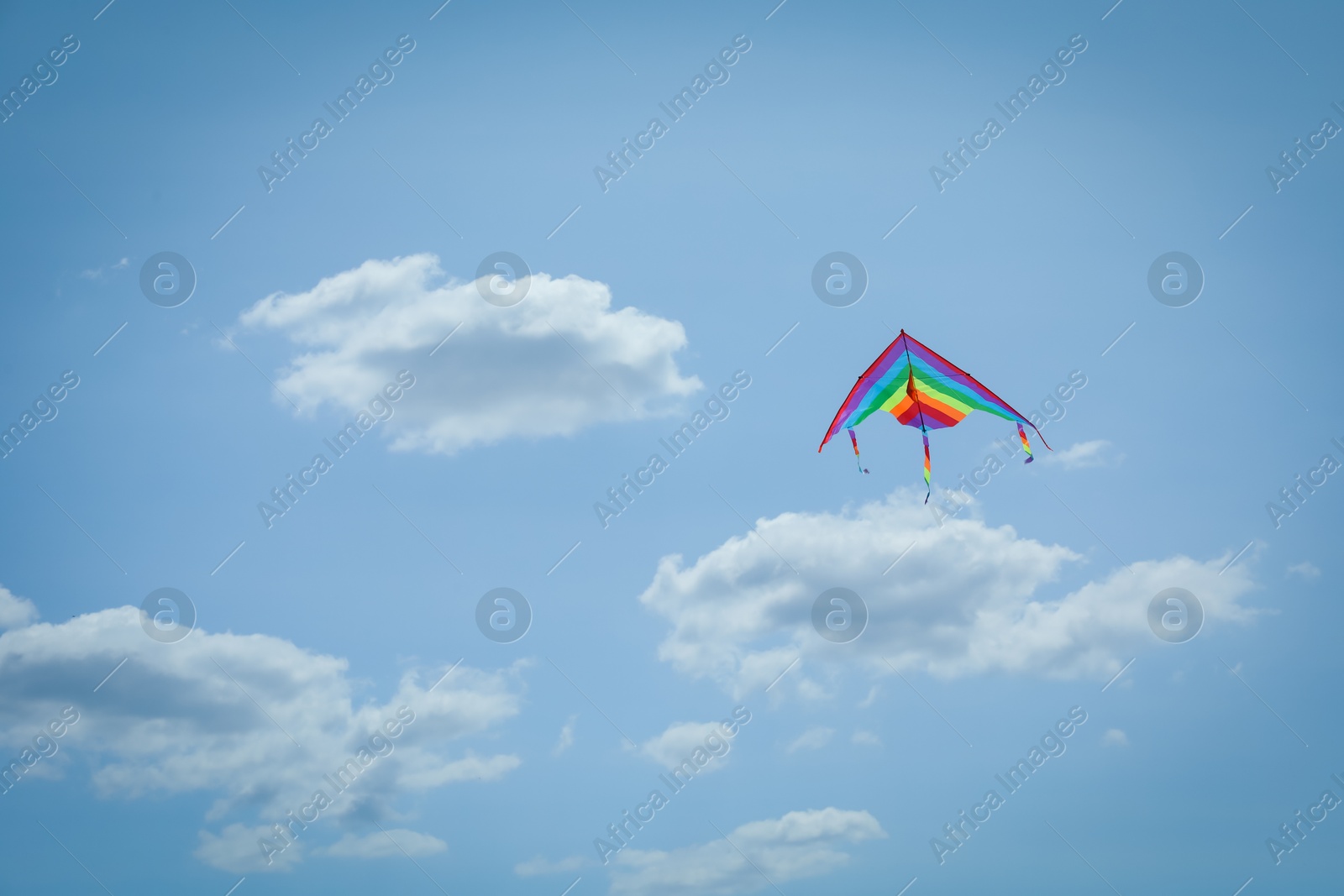 Colorful kite flying in blue sky, low angle view. Space for text Photo of Colorful kite flying in blue sky, low angle view. Space for text