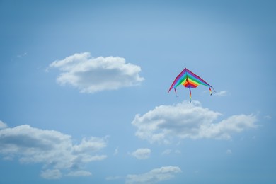Photo of Colorful kite flying in blue sky, low angle view. Space for text