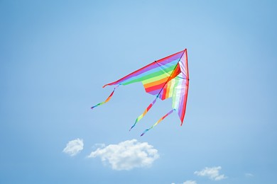 Photo of Colorful kite flying in blue sky, low angle view