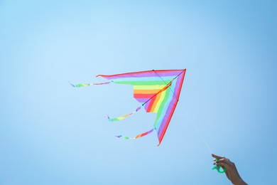 Photo of Woman with colorful kite under blue sky, low angle view