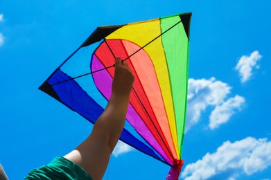 Photo of Woman with colorful kite under blue sky, low angle view