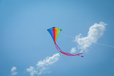 Photo of Colorful kite flying in blue sky, low angle view