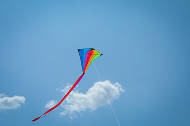 Photo of Colorful kite flying in blue sky, low angle view