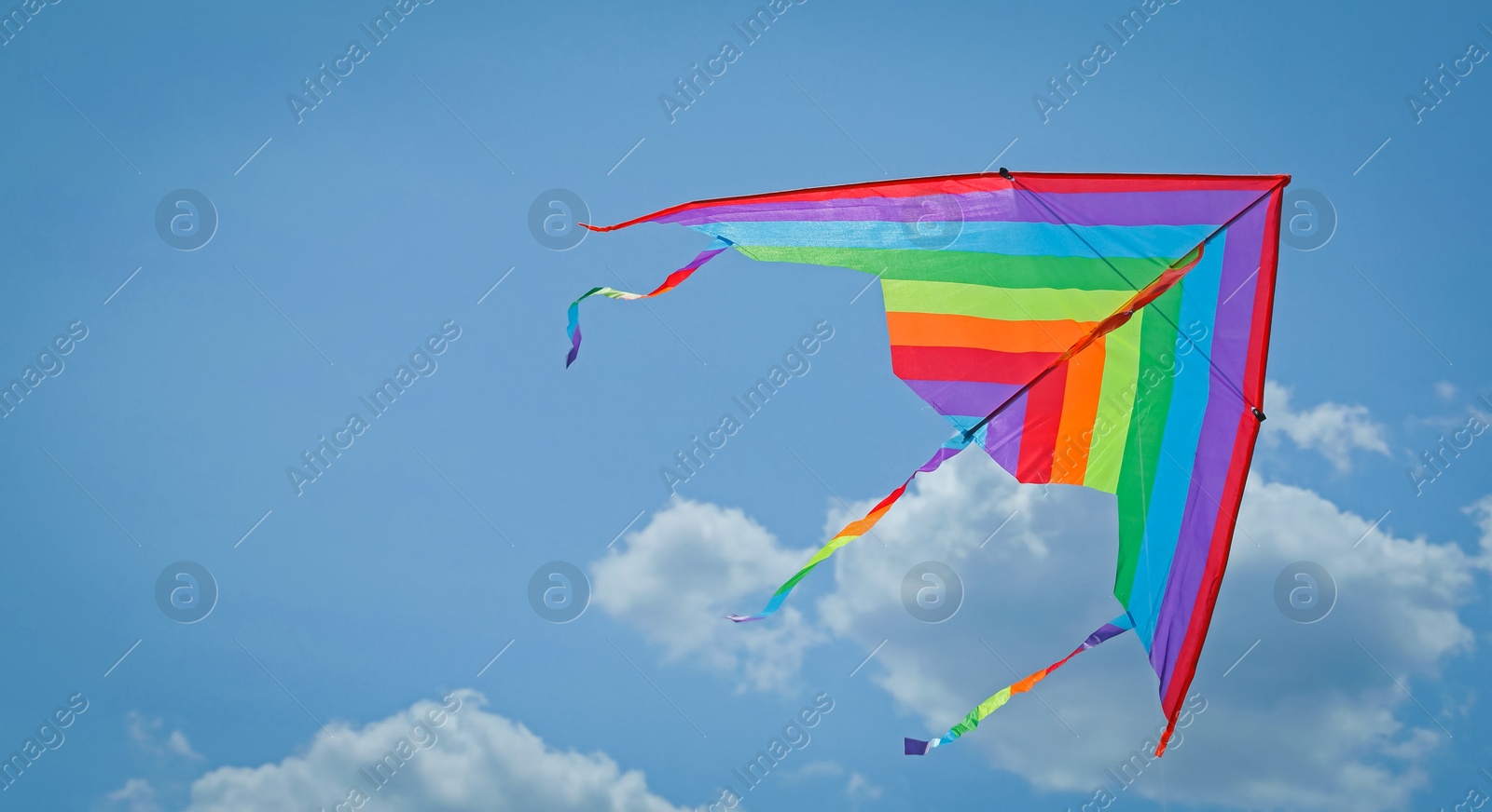 Colorful kite flying in blue sky, bottom view. Space for text Photo of Colorful kite flying in blue sky, bottom view. Space for text