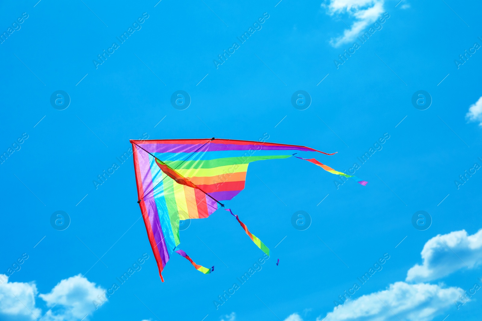 Colorful kite flying in blue sky, bottom view Photo of Colorful kite flying in blue sky, bottom view