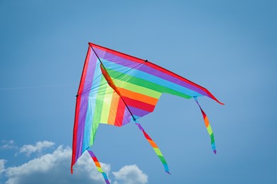 Photo of Colorful kite flying in blue sky, bottom view
