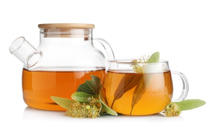 Photo of Tasty linden tea in cup, teapot, leaves and flowers isolated on white