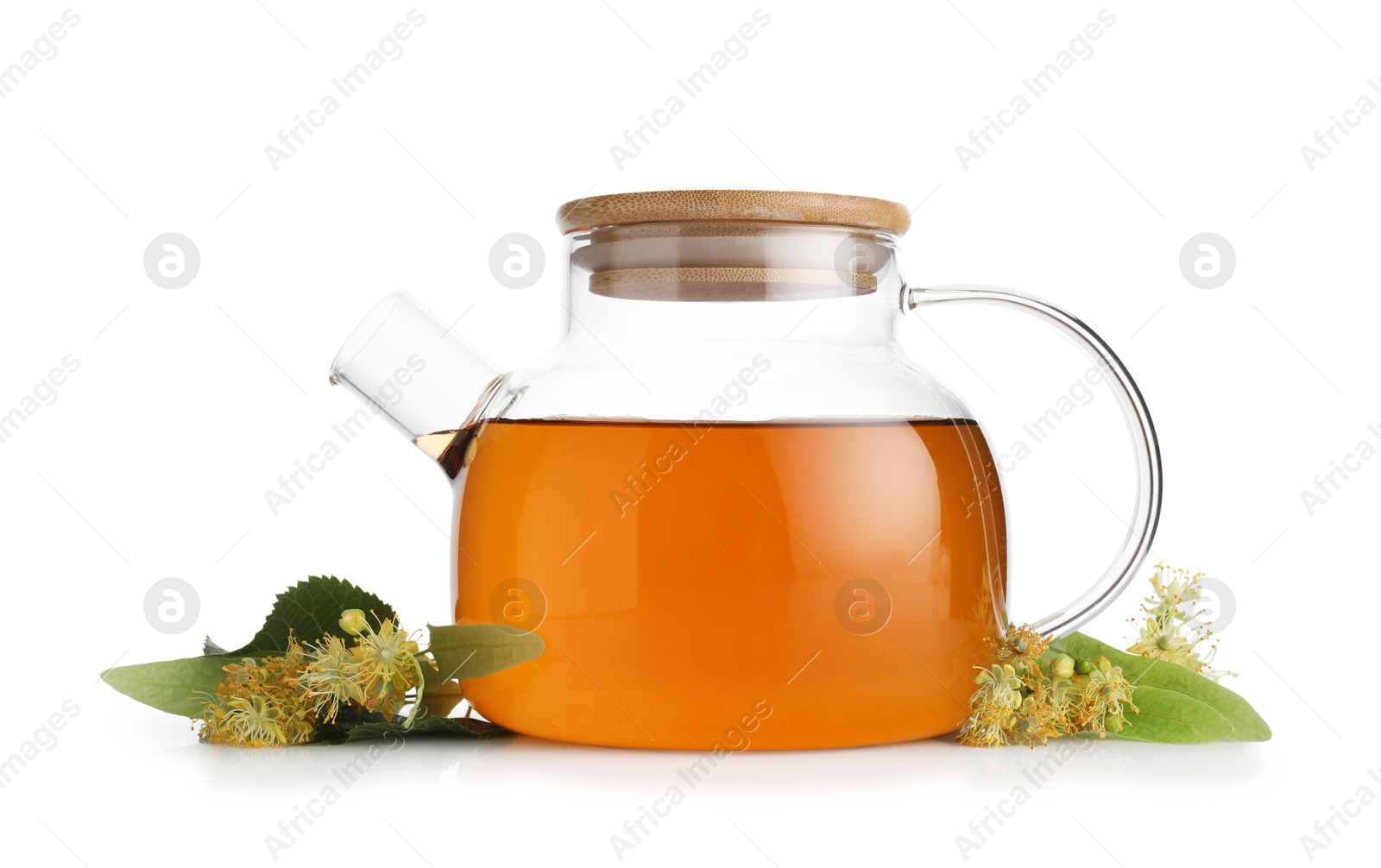 Tasty linden tea in teapot, leaves and flowers isolated on white Photo of Tasty linden tea in teapot, leaves and flowers isolated on white