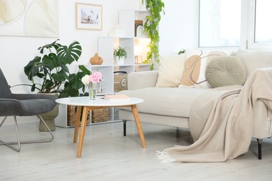 Photo of Comfortable sofa with coffee table and armchair in room. Interior design