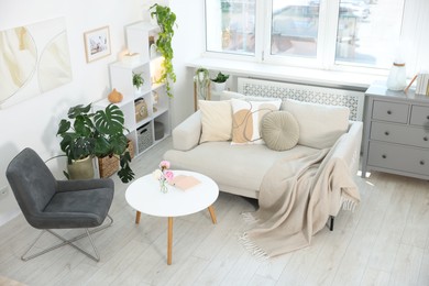 Photo of Comfortable sofa with coffee table and armchair in room, above view