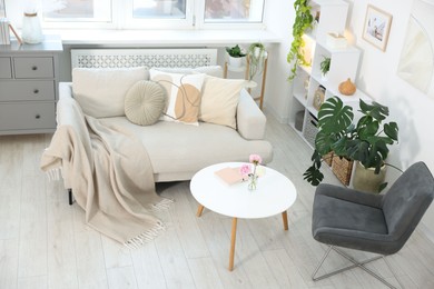 Photo of Comfortable sofa with coffee table and armchair in room, above view