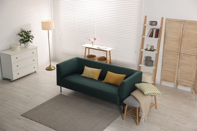 Photo of Comfortable sofa with cushions in room, above view