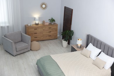 Photo of Bed, armchair and chest of drawers in room, above view