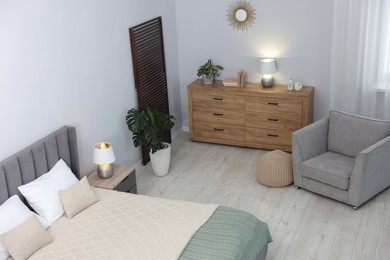 Photo of Bed, armchair and chest of drawers in room, above view