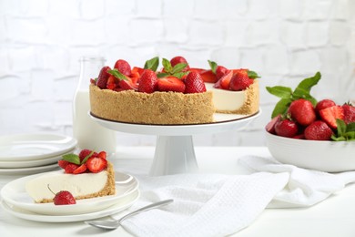 Photo of Delicious cheesecake with strawberries, mint and milk on white wooden table