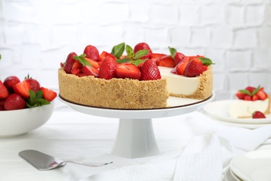 Photo of Delicious cheesecake with strawberries and mint on white wooden table, closeup