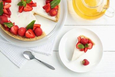 Photo of Delicious cheesecake with strawberries, mint and tea on white wooden table, flat lay