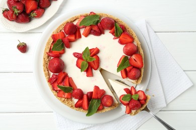 Photo of Delicious cheesecake with strawberries and mint on white wooden table, flat lay
