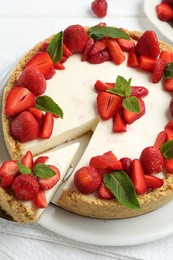Photo of Delicious cheesecake with strawberries and mint on table, above view