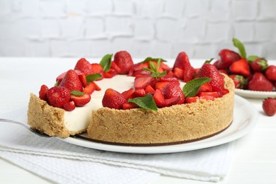 Photo of Delicious cheesecake with strawberries and mint on white table, closeup