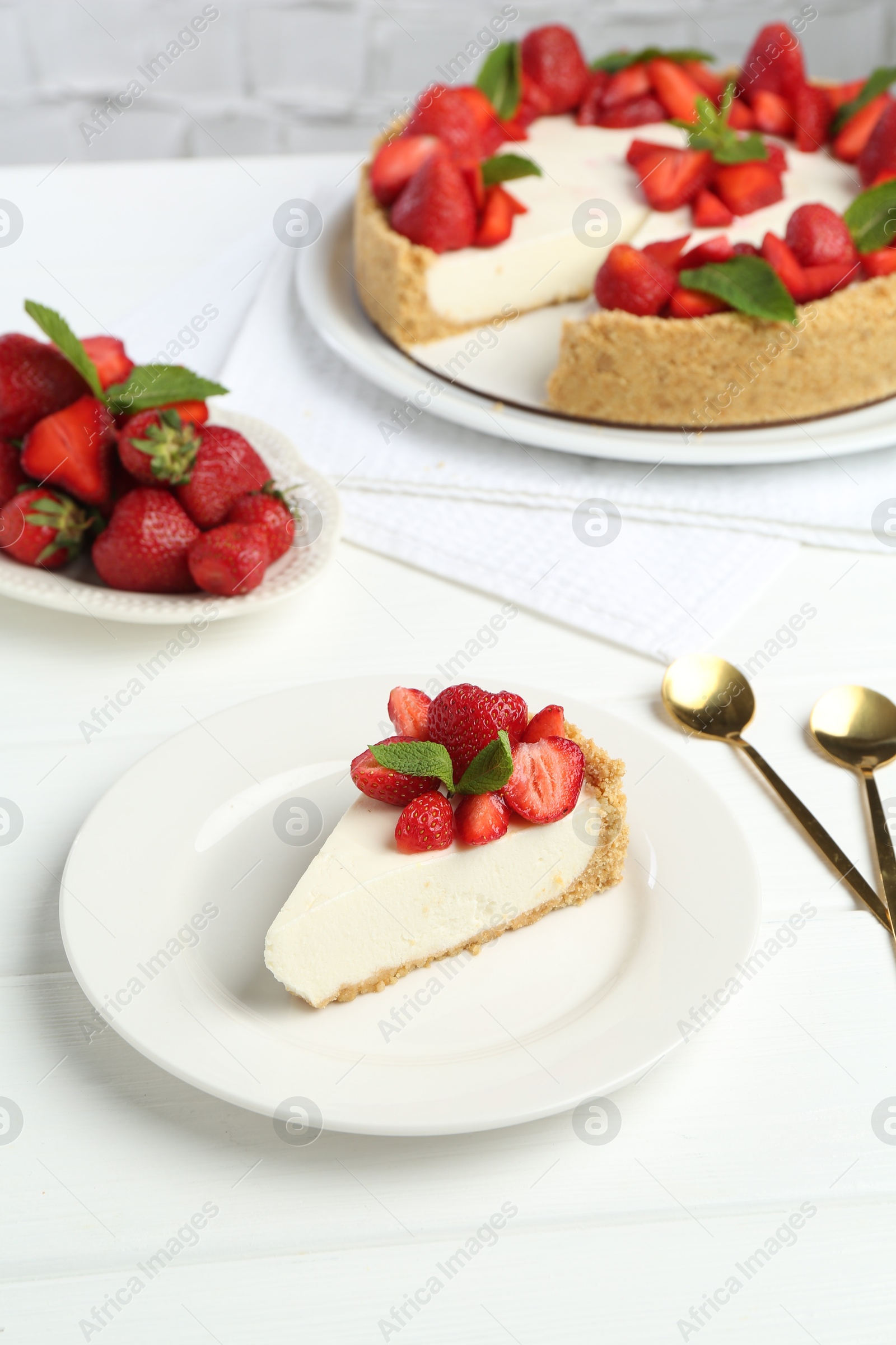 Photo of Delicious cheesecake with strawberries and mint on white wooden table, above view