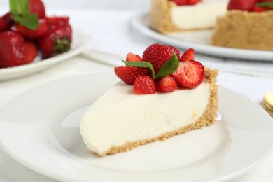 Photo of Piece of tasty cheesecake with strawberries and mint on table, closeup