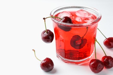 Photo of Tasty cherry soda with ice cubes and berries on white wooden table, closeup. Space for text