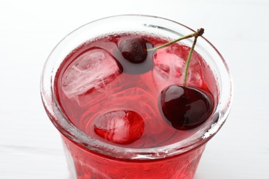Photo of Tasty cherry soda with ice cubes and berries on white wooden table, closeup