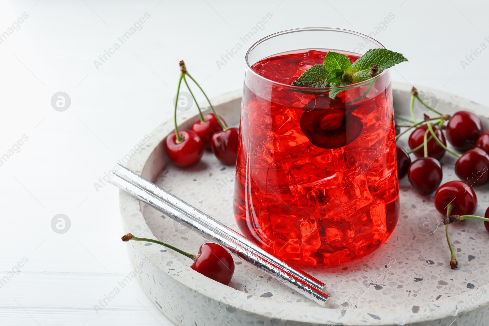 Tasty cherry soda with ice cubes, mint and berries on white wooden table, closeup. Space for text Photo of Tasty cherry soda with ice cubes, mint and berries on white wooden table, closeup. Space for text